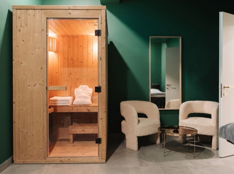 La sauna a infrarossi accesa nella cabina spa, con le poltroncine in bouclé da Hesteta (immagine illustrativa)